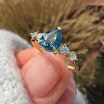 pear shape blue teal sapphire engagement ring set in yellow gold