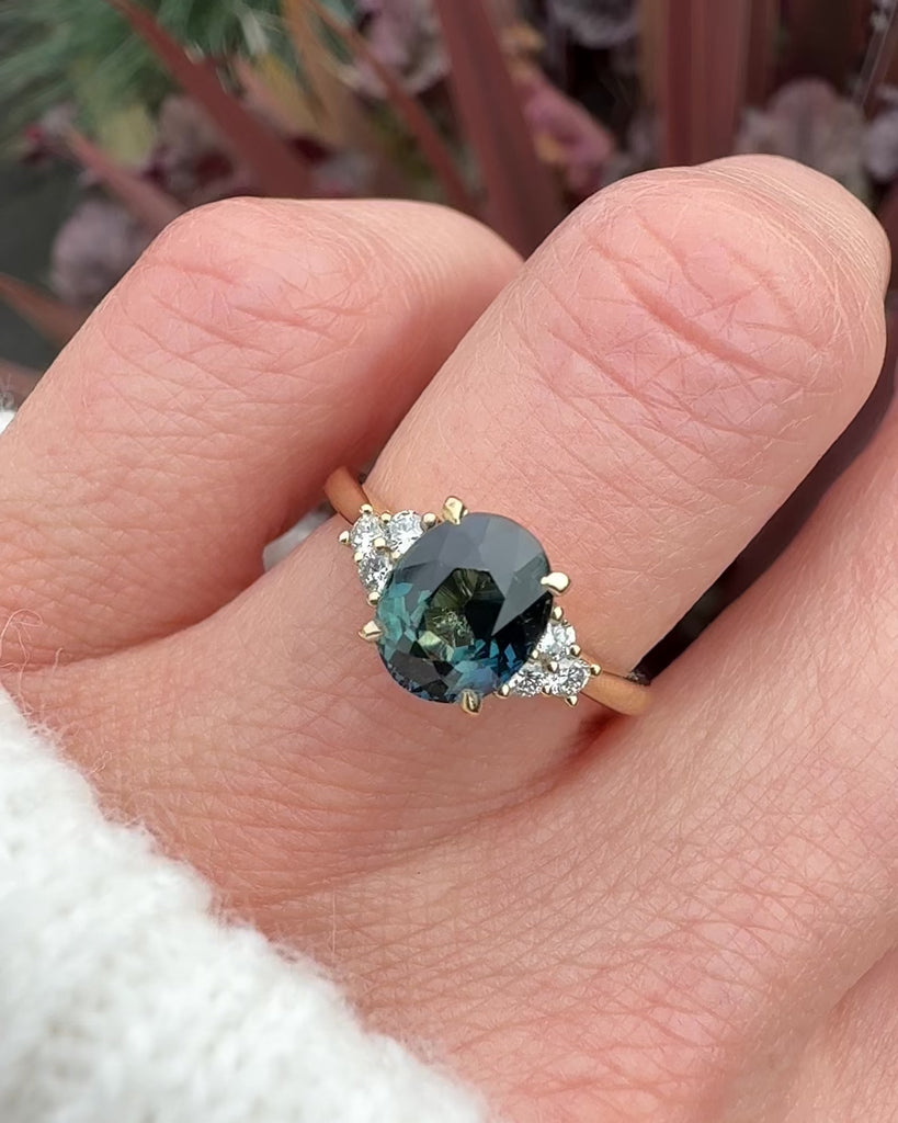 unheated teal blue oval sapphire engagement ring in yellow gold