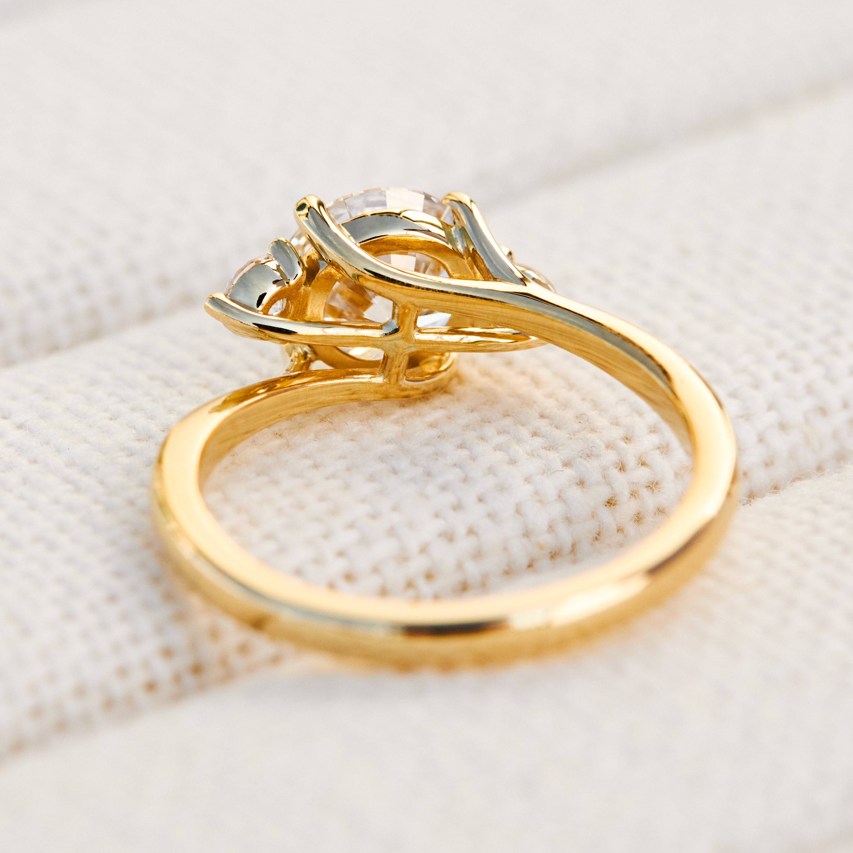 round brilliant cut trilogy diamond engagement ring set in yellow gold