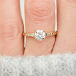 round brilliant cut diamond trilogy engagement ring with tapered baguette shoulders