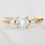 round brilliant cut diamond trilogy engagement ring with tapered baguette shoulders