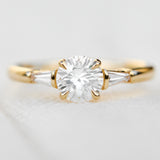 round brilliant cut diamond trilogy engagement ring with tapered baguette shoulders