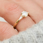 round brilliant cut diamond trilogy engagement ring with tapered baguette shoulders
