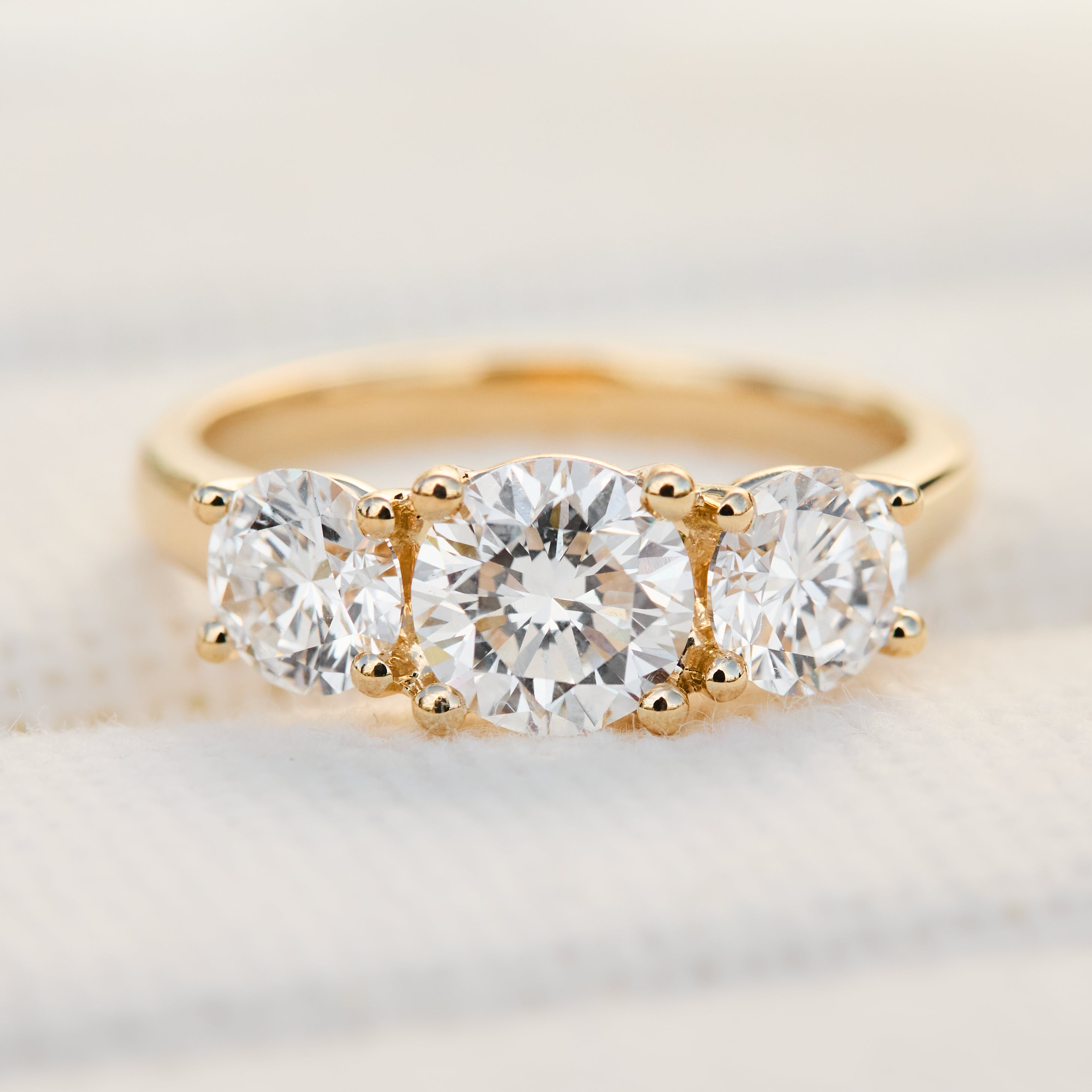 round brilliant cut lab grown diamond yellow gold trilogy engagement ring