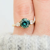 round brilliant cut madagascan teal sapphire trilogy engagement ring
