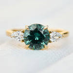 round brilliant cut madagascan teal sapphire trilogy engagement ring