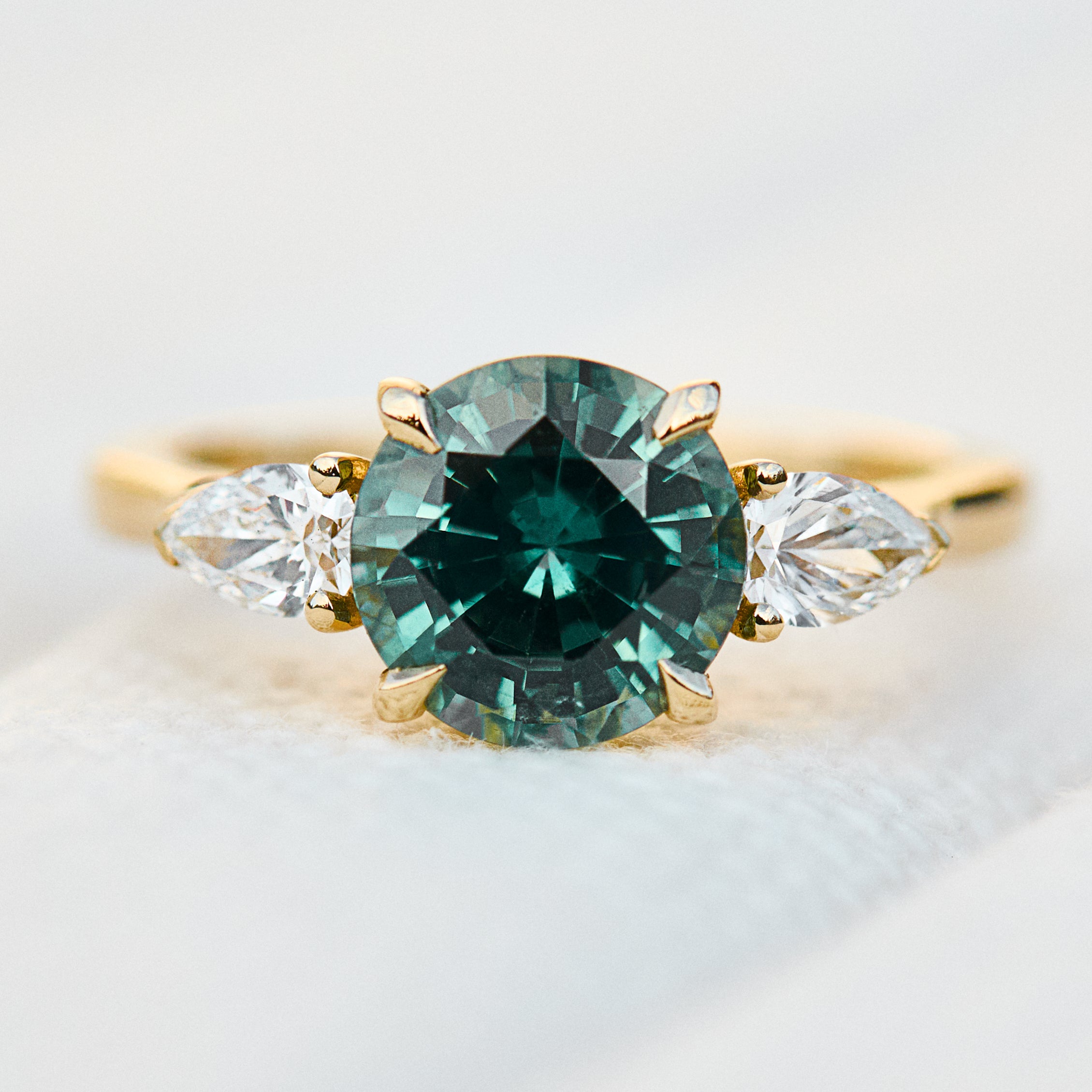 round brilliant cut madagascan teal sapphire trilogy engagement ring