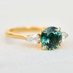 round brilliant cut madagascan teal sapphire trilogy engagement ring