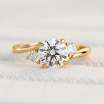 round brilliant cut trilogy diamond engagement ring set in yellow gold