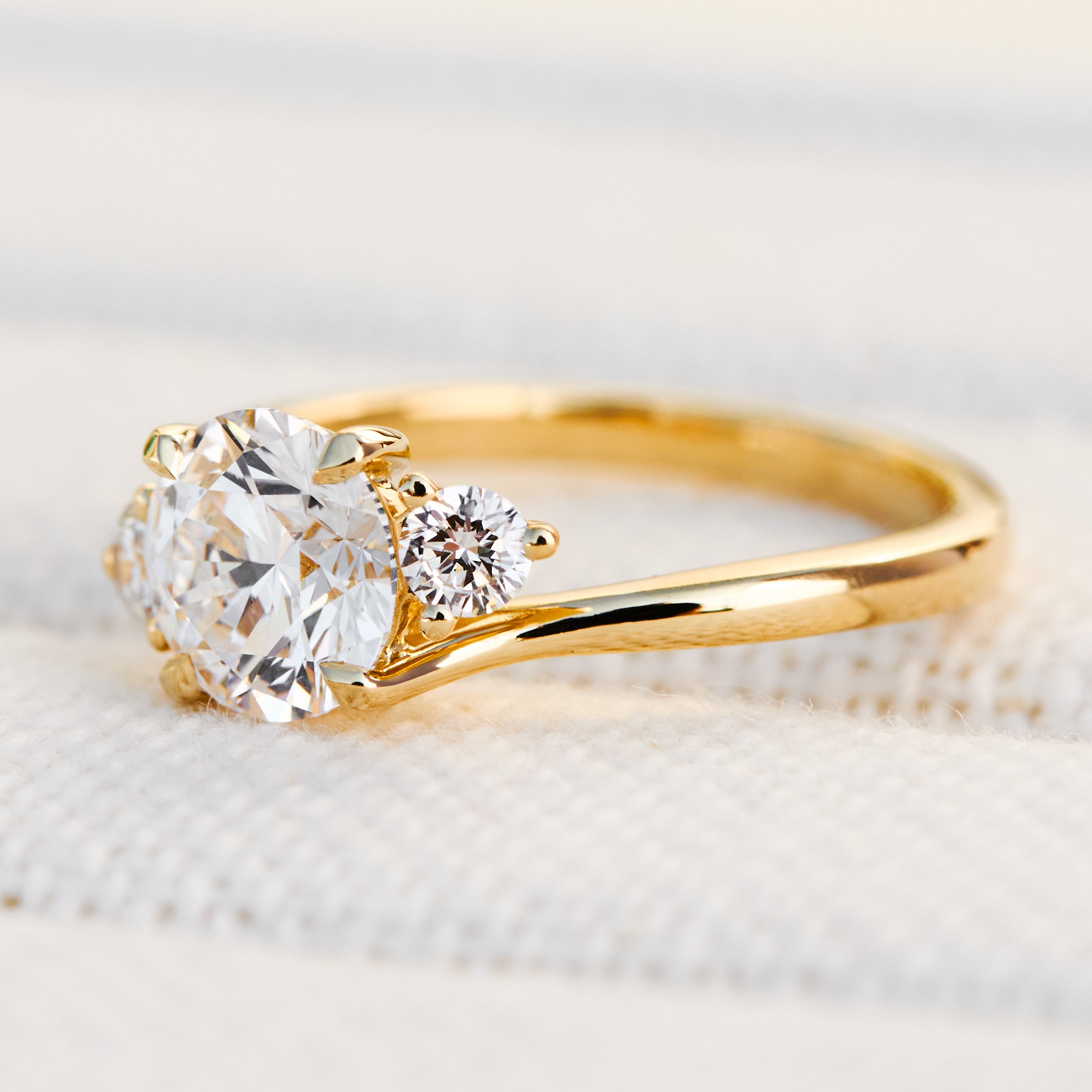 round brilliant cut trilogy diamond engagement ring set in yellow gold