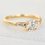 round brilliant cut diamond trilogy engagement ring with tapered baguette shoulders