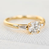 round brilliant cut diamond trilogy engagement ring with tapered baguette shoulders