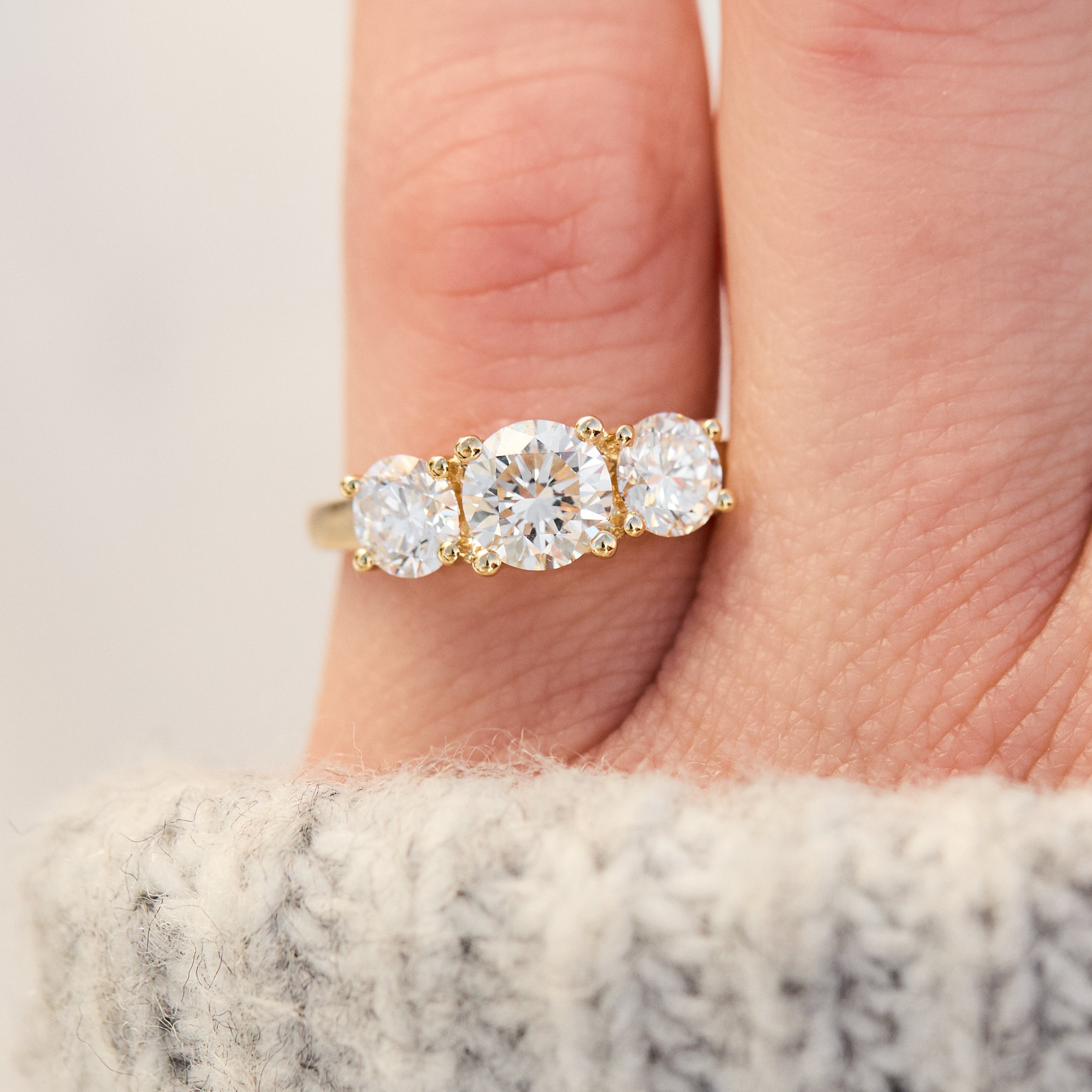 round brilliant cut lab grown diamond yellow gold trilogy engagement ring