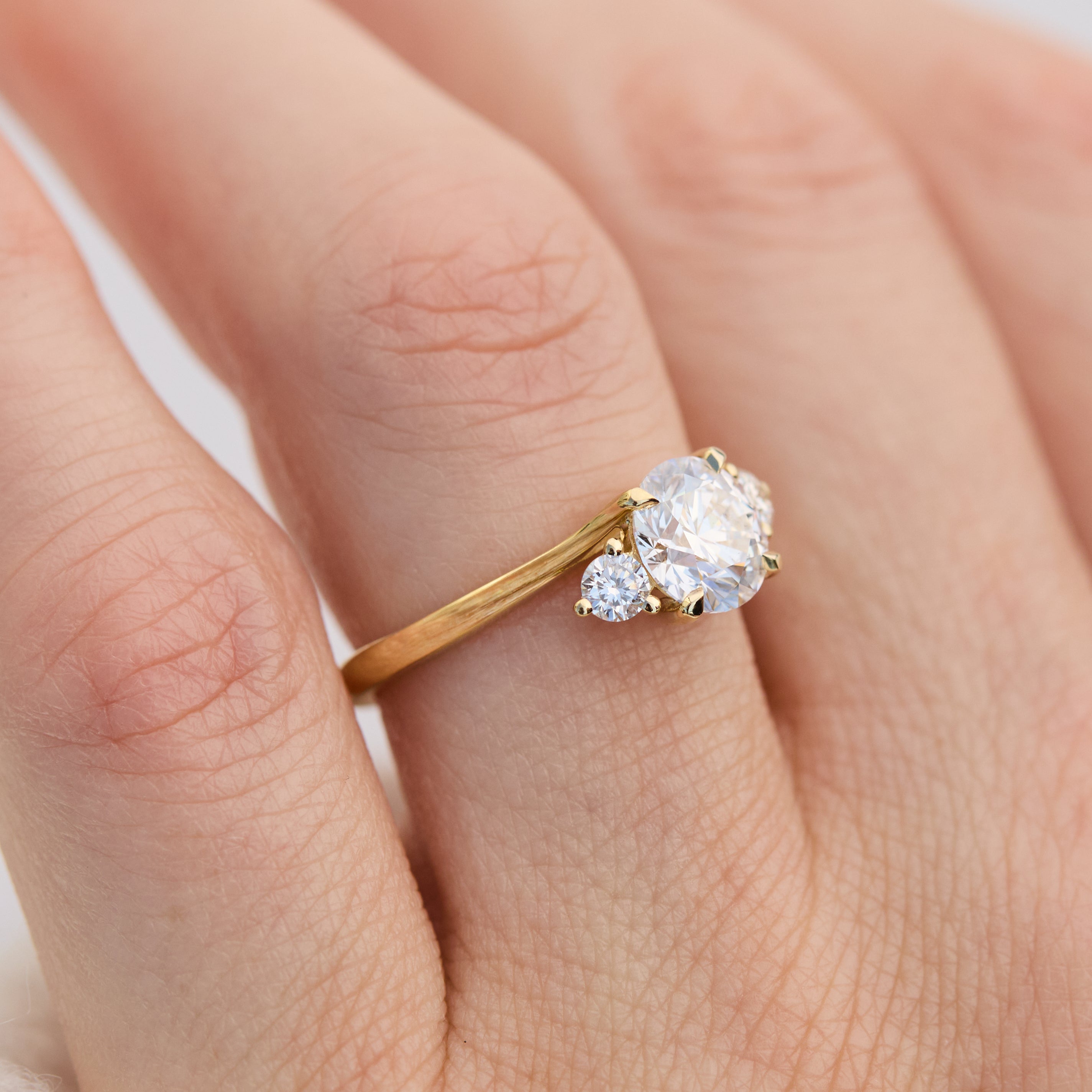 round brilliant cut trilogy diamond engagement ring set in yellow gold