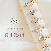 Gold rings with diamonds on a white surface, featuring the Sophia Perez brand.