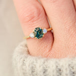 tanzanian oval teal sapphire trilogy engagement ring in yellow gold