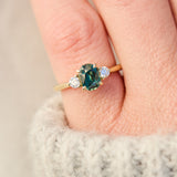 tanzanian oval teal sapphire trilogy engagement ring in yellow gold