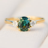 tanzanian oval teal sapphire trilogy engagement ring in yellow gold