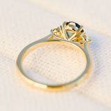 tanzanian oval teal sapphire trilogy engagement ring in yellow gold