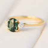 tanzanian oval teal sapphire trilogy engagement ring in yellow gold