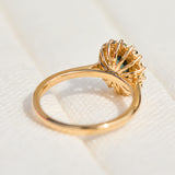 oval teal montana sapphire engagement ring in yellow gold with a diamond halo