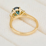 unheated teal blue oval sapphire engagement ring in yellow gold