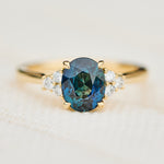 unheated teal blue oval sapphire engagement ring in yellow gold