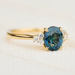 unheated teal blue oval sapphire engagement ring in yellow gold