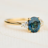 unheated teal blue oval sapphire engagement ring in yellow gold