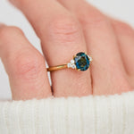 unheated teal blue oval sapphire engagement ring in yellow gold
