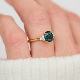 unheated teal blue oval sapphire engagement ring in yellow gold