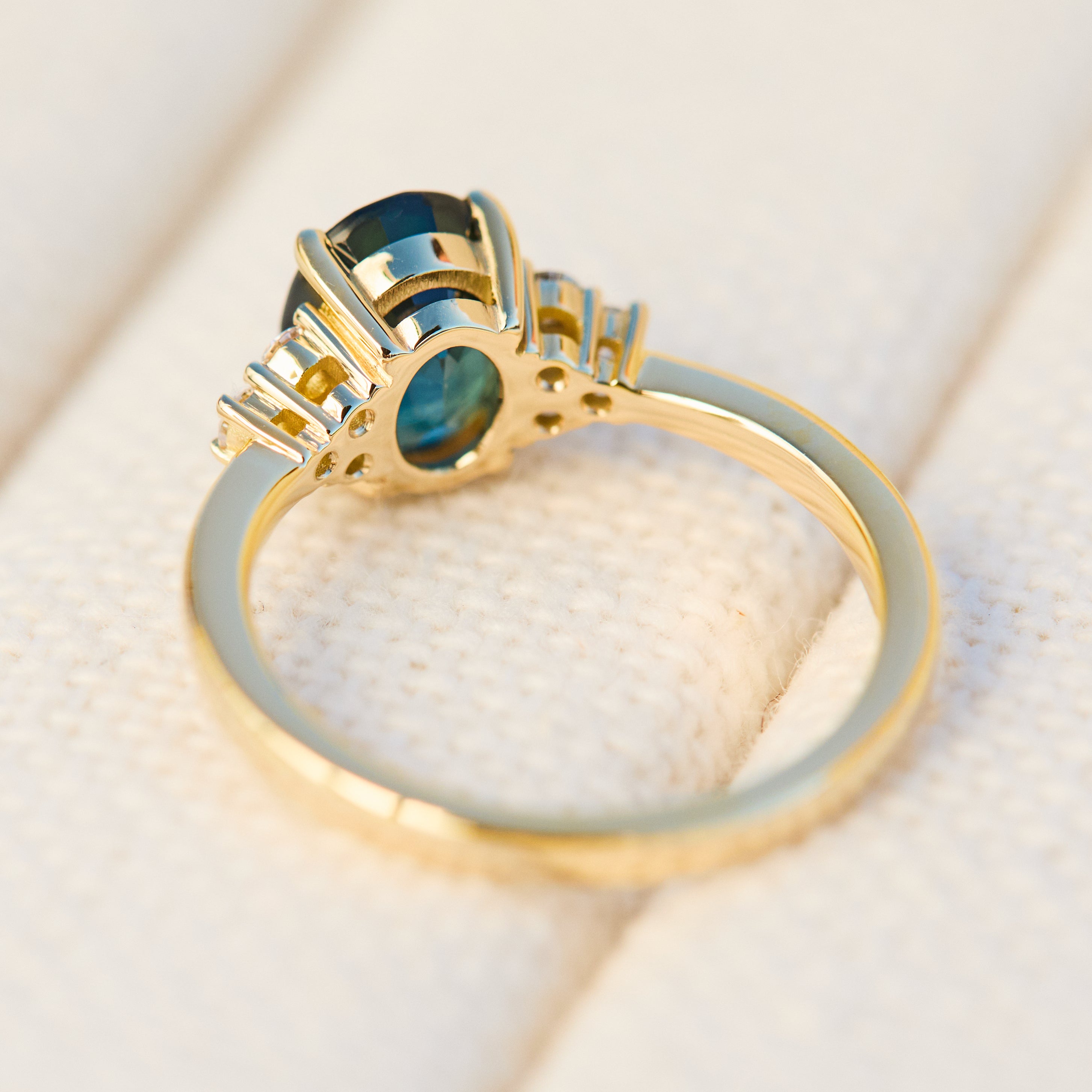 australian oval teal sapphire engagement ring with round diamond side stones