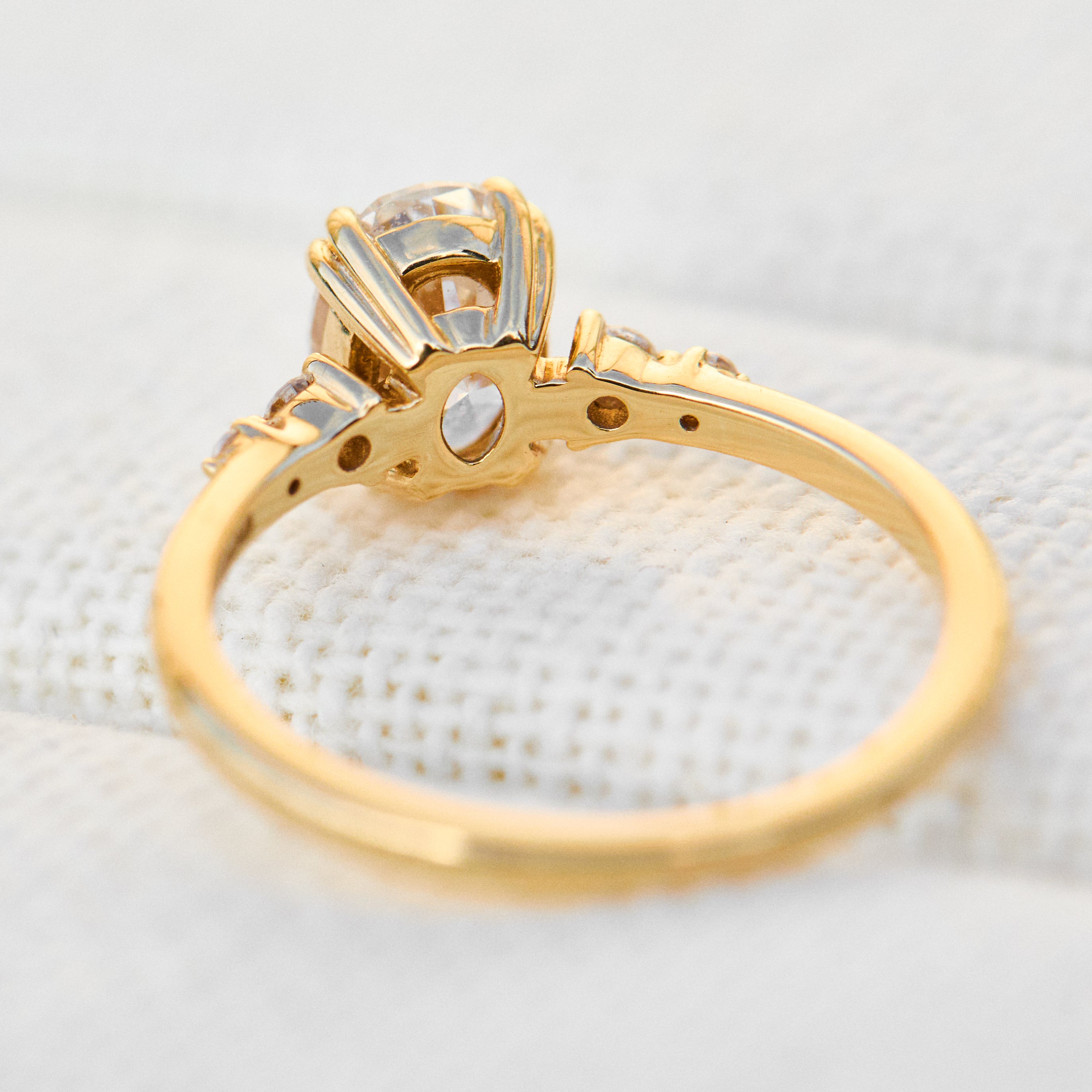 cushion cut moissanite and diamond engagement ring in yellow gold