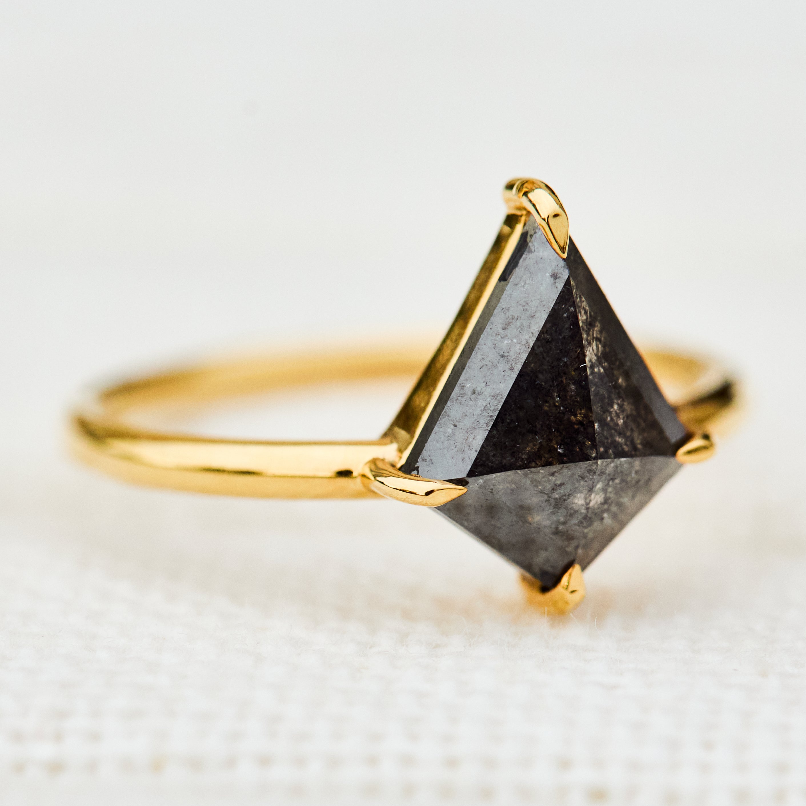 yellow gold solitaire ring with a kite shape salt and pepper diamond