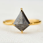yellow gold solitaire ring with a kite shape salt and pepper diamond
