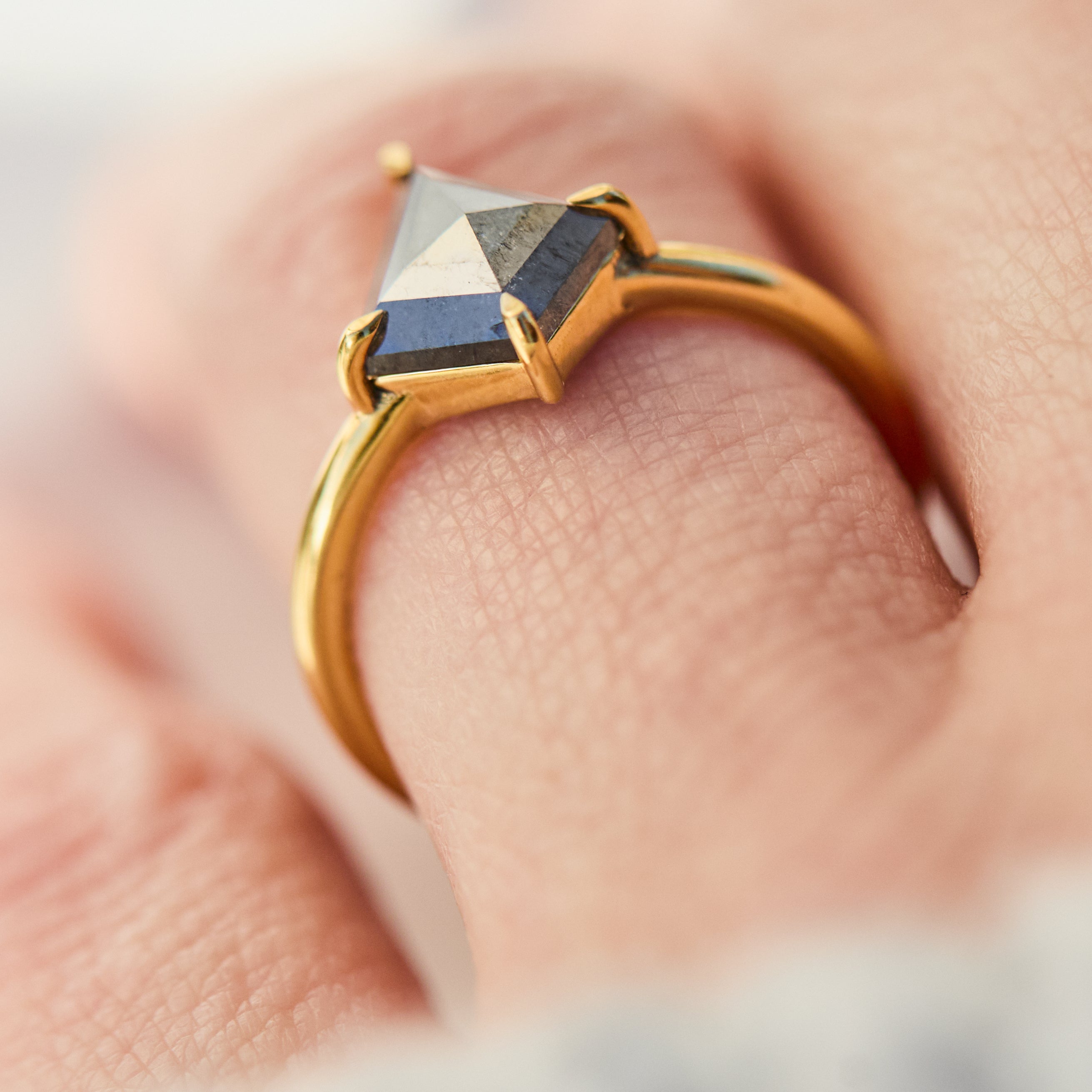 yellow gold solitaire ring with a kite shape salt and pepper diamond