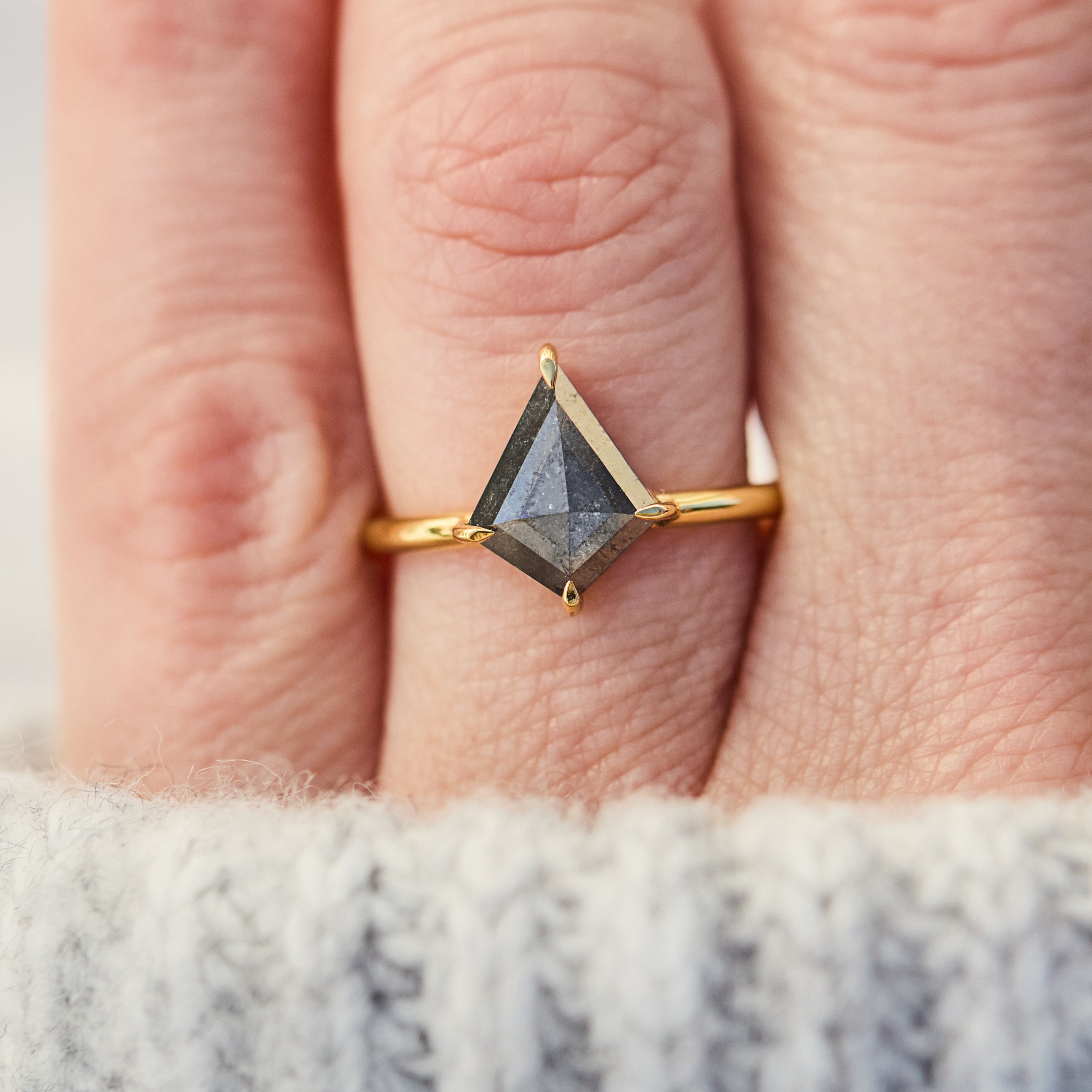 yellow gold solitaire ring with a kite shape salt and pepper diamond