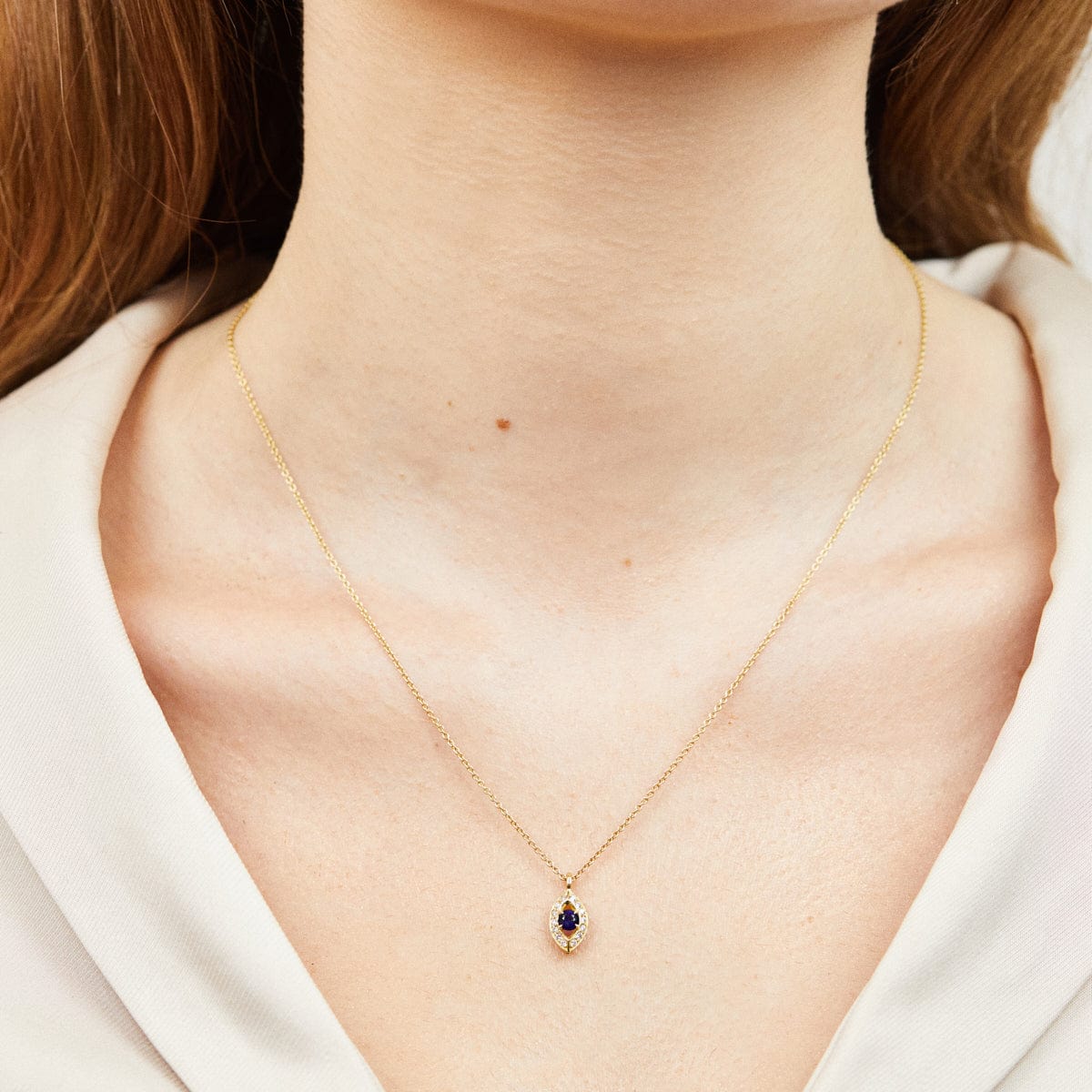 Blue sapphire evil eye necklace with diamonds in 18ct yellow gold.
